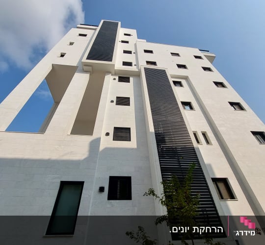 התקנת רשתות נגד יונים במסתורי כביסה בחזית בניין מגורים גבוה